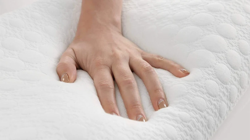 La mano di una donna che preme un materasso in memory foam