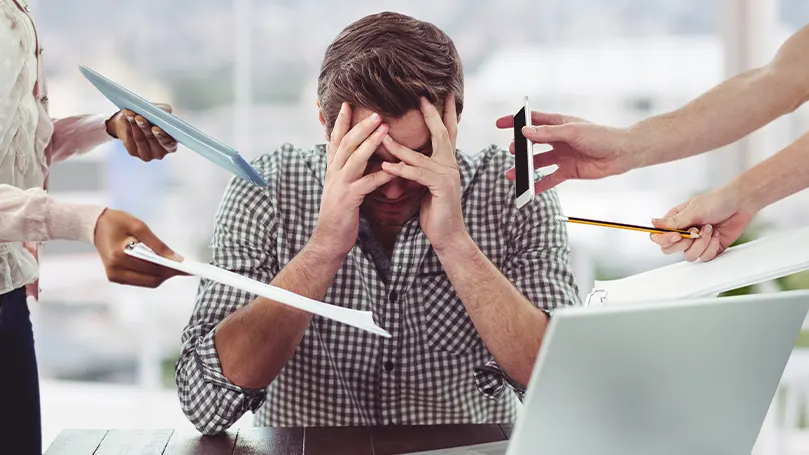 L'immagine di un uomo che viene travolto da persone che gli avvicinano fogli e telefoni alla testa