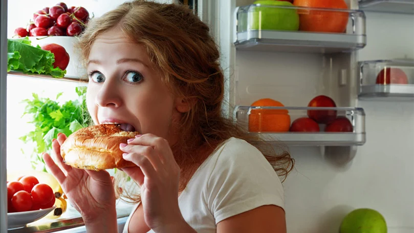 l'immagine di una donna che fa uno spuntino a tarda notte