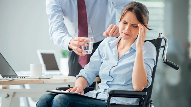 un'immagine di una donna che soffre di emicrania al lavoro