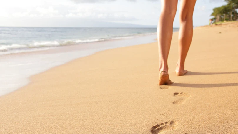 una donna che cammina sulla spiaggia