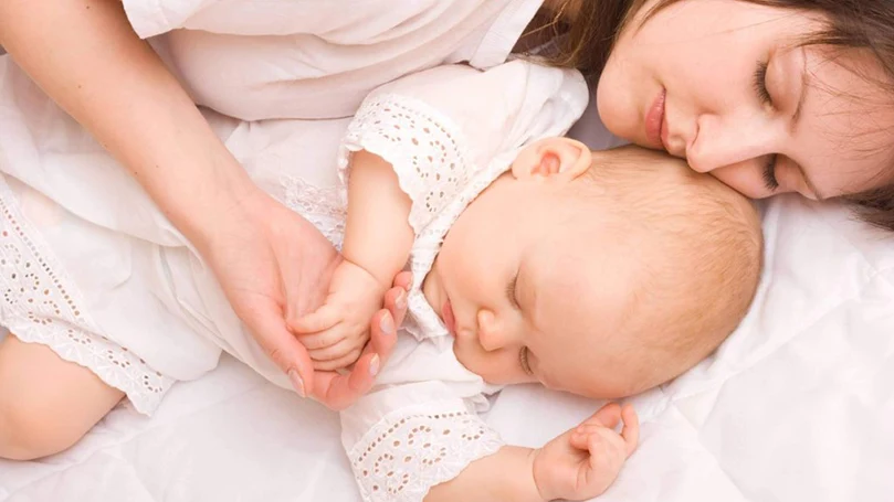 un'immagine di una madre che dorme con un bambino