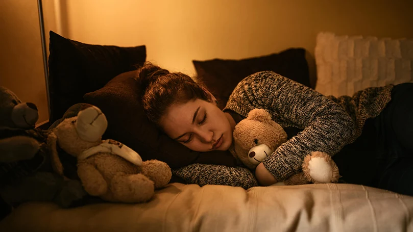 una donna dorme nel letto con la luce accesa