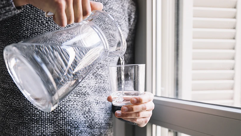 l'immagine di una donna che si versa un bicchiere d'acqua