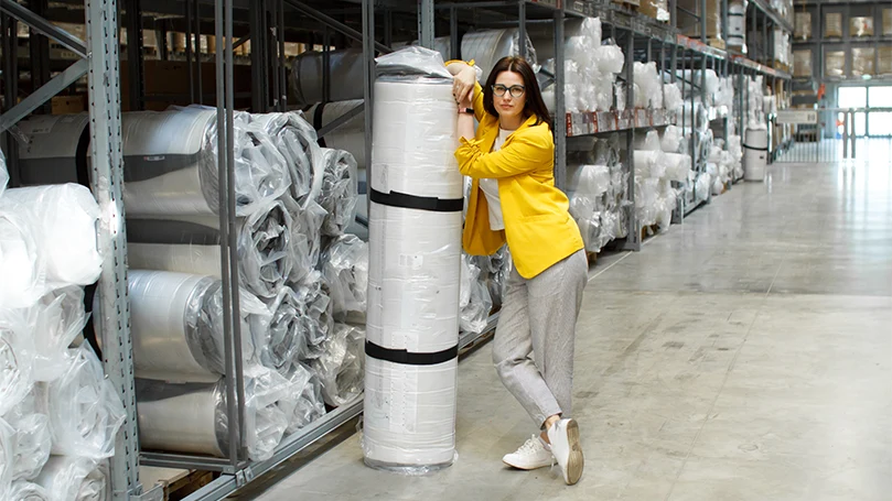 l'immagine di una donna che tiene in mano un materasso arrotolato e impacchettato