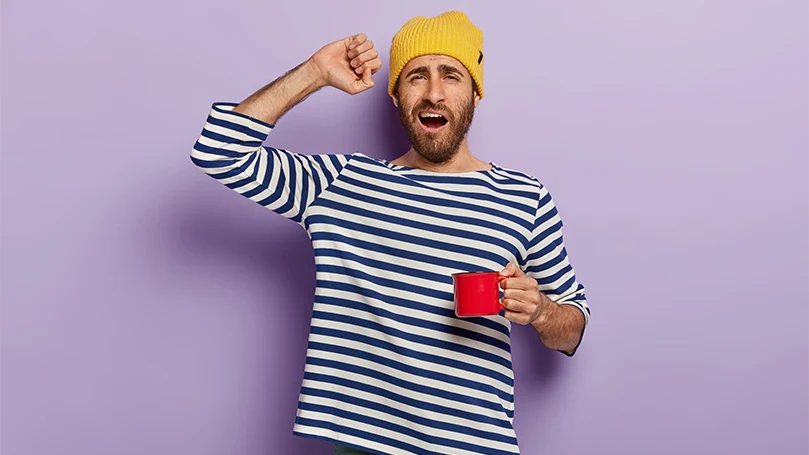 Un'immagine di un uomo che inizia la sua mattinata con una tazza di caffè.