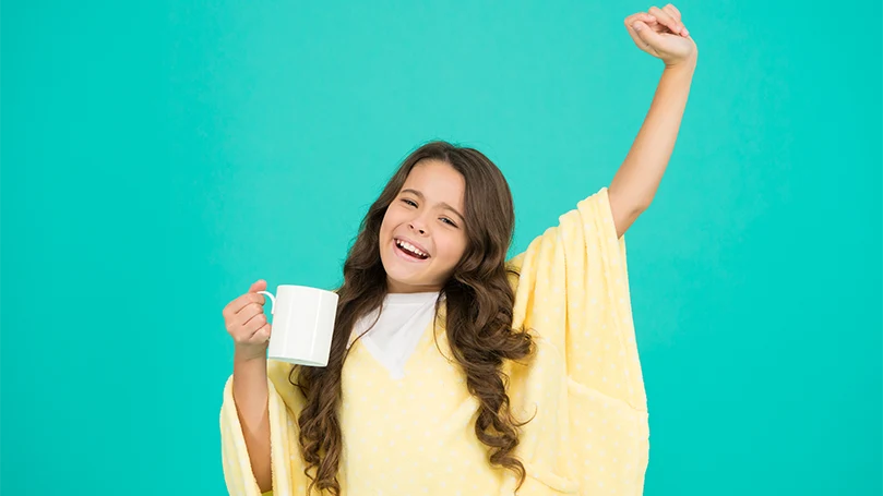 Featured image of Una ragazza assonnata con un bicchiere di latte prima di andare a letto.