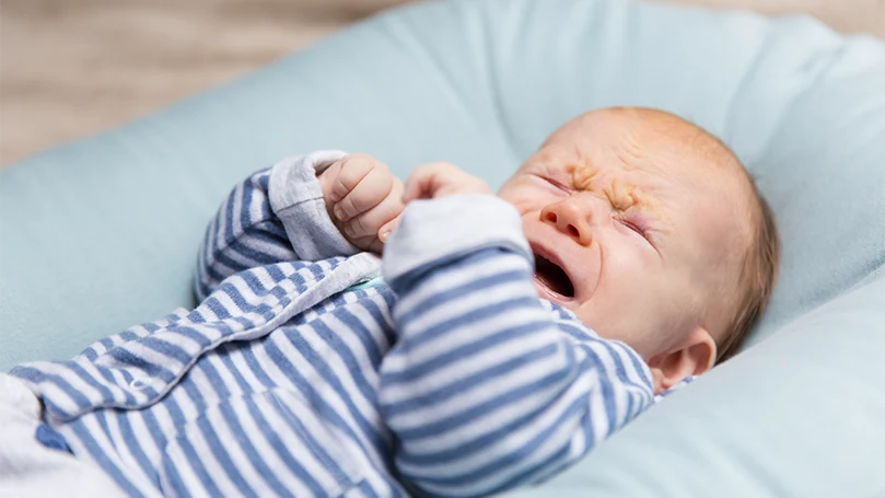 Un'immagine di un bambino che piange nel materasso della culla.