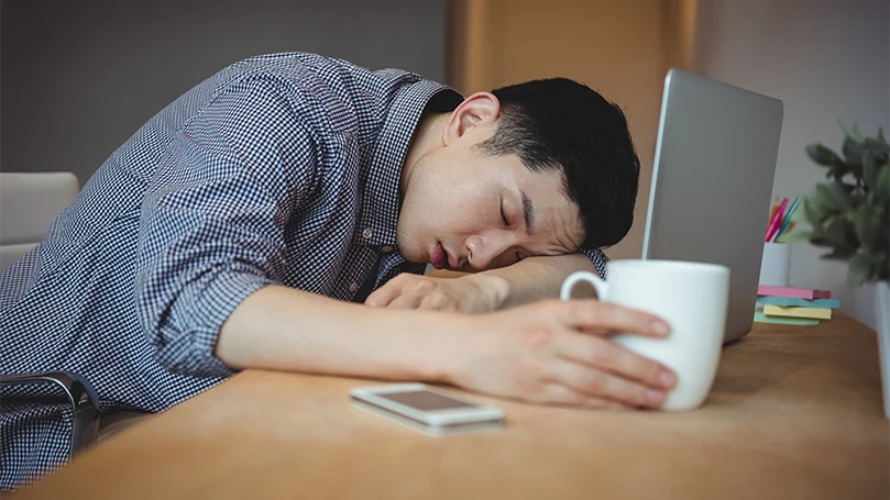 L'immagine di un uomo addormentato nel suo ufficio.