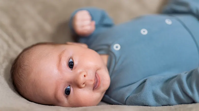 Un'immagine di un bambino di 2 mesi sdraiato sulla schiena.