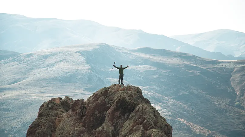 Un escursionista in cima a una montagna.