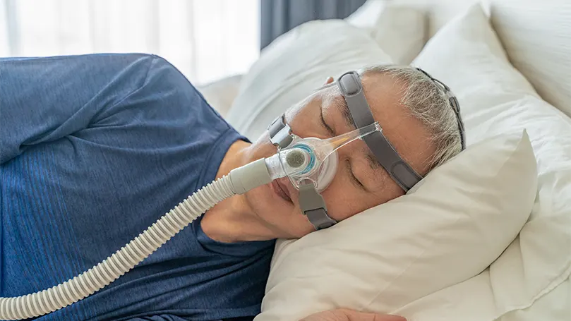 Un uomo anziano che dorme con la maschera CPAP