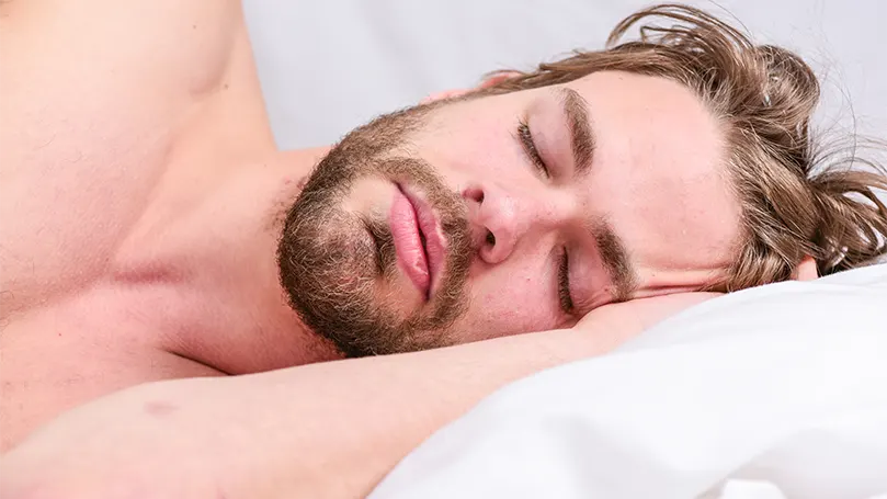 Immagine di un giovane uomo che dorme in una fase di sonno profondo.