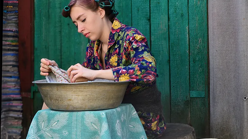 Immagine di una giovane donna che immerge il pigiama in acqua tiepida.