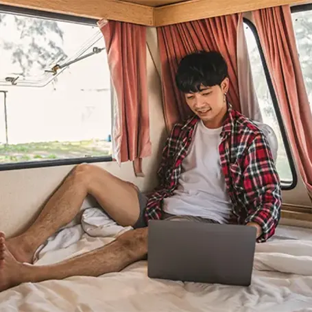 Un uomo con un computer portatile in un camper