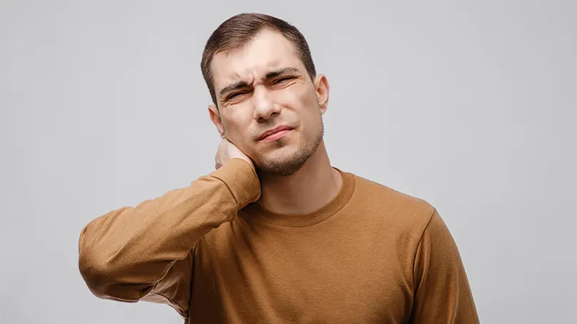 Un'immagine di un giovane uomo che prova dolore a causa di problemi ai nervi.