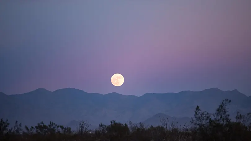 Un'immagine della luna piena di sera.