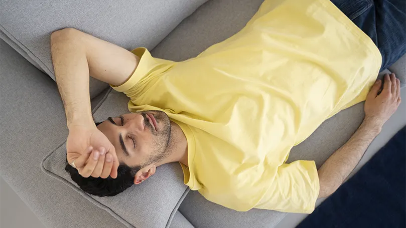 Un'immagine di un uomo in camicia gialla che dorme senza russare