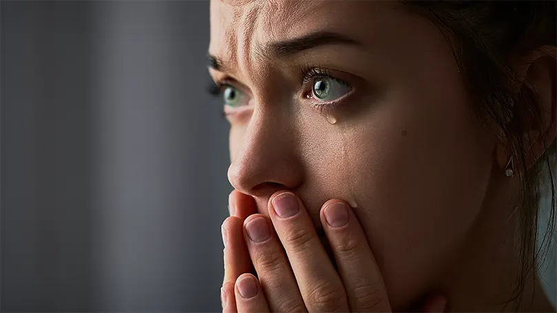 L'immagine di una donna triste con gli occhi verdi che piange.