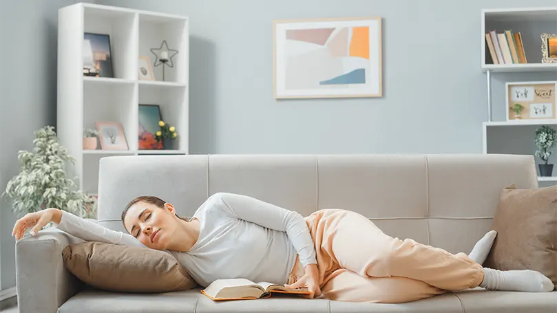 Immagine di una donna che dorme su un fianco su un divano.