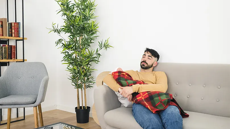 Immagine di un giovane uomo che dorme sul divano con un bambino.