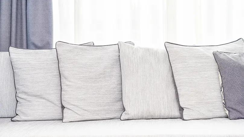 An image of pillows & bedding on couch.