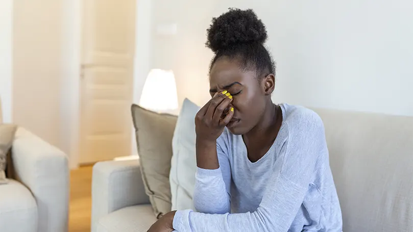 Un'immagine di una giovane donna di colore che si affatica gli occhi,