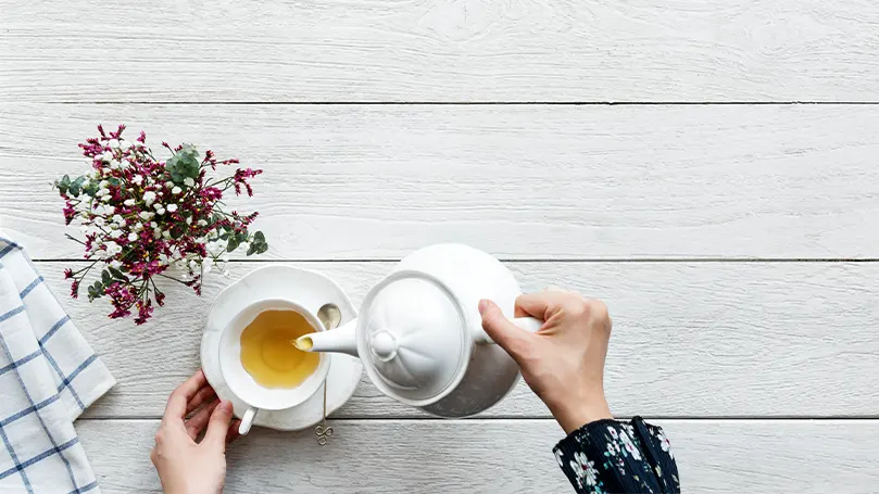 L'immagine di una persona che versa del tè bianco nella propria tazza