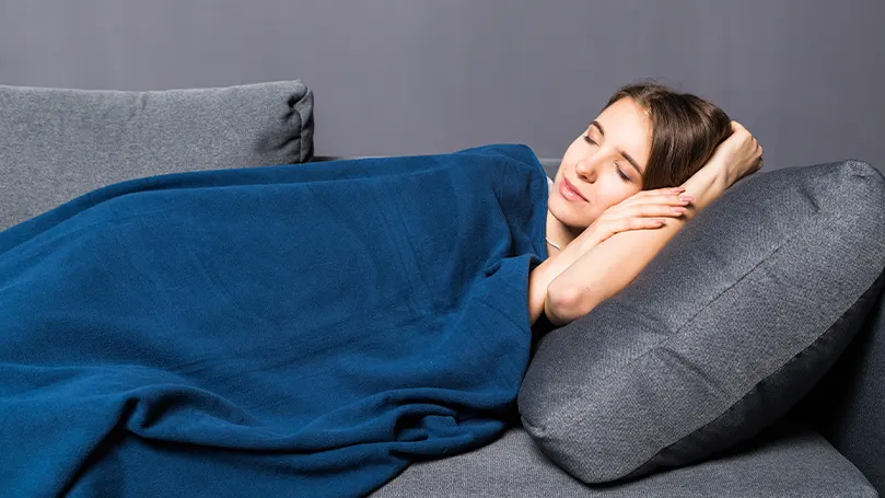 Un'immagine di una donna che dorme sotto una coperta appesantita