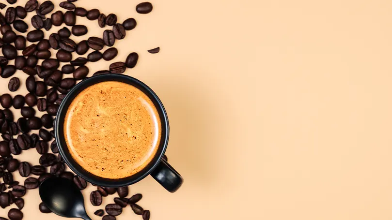 Immagine di una tazza di caffè con fagioli di caffè a lato