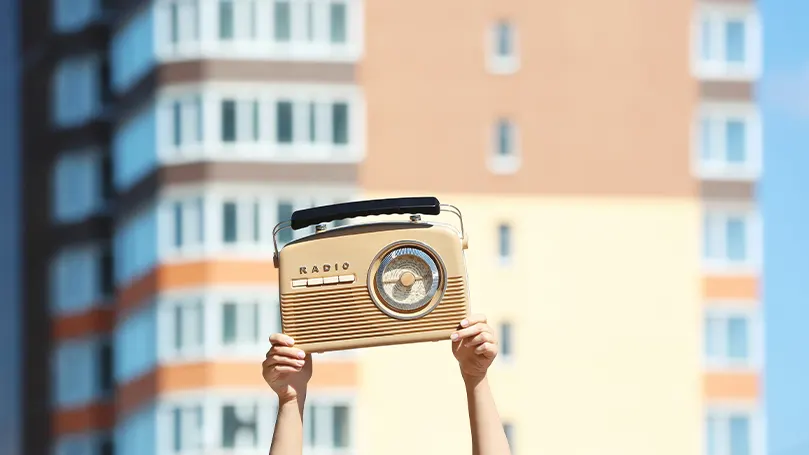 Immagine di una persona che tiene in mano una radio.