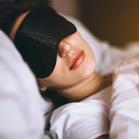 Immagine di una donna che dorme con una maschera per dormire