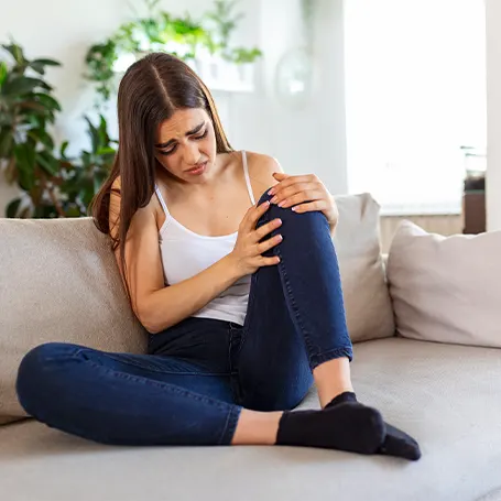 L'immagine di una donna con dolore alla gamba che si tiene il ginocchio