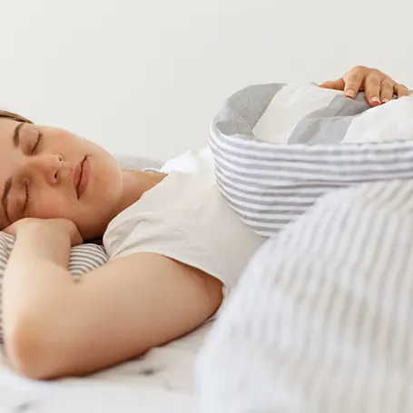 Un'immagine di una donna che dorme su un materasso con un buon supporto per la schiena